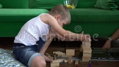 在这个视频中，你可以看到年轻的家庭在家中玩地板木塔。 家庭游戏。 紧密结合
